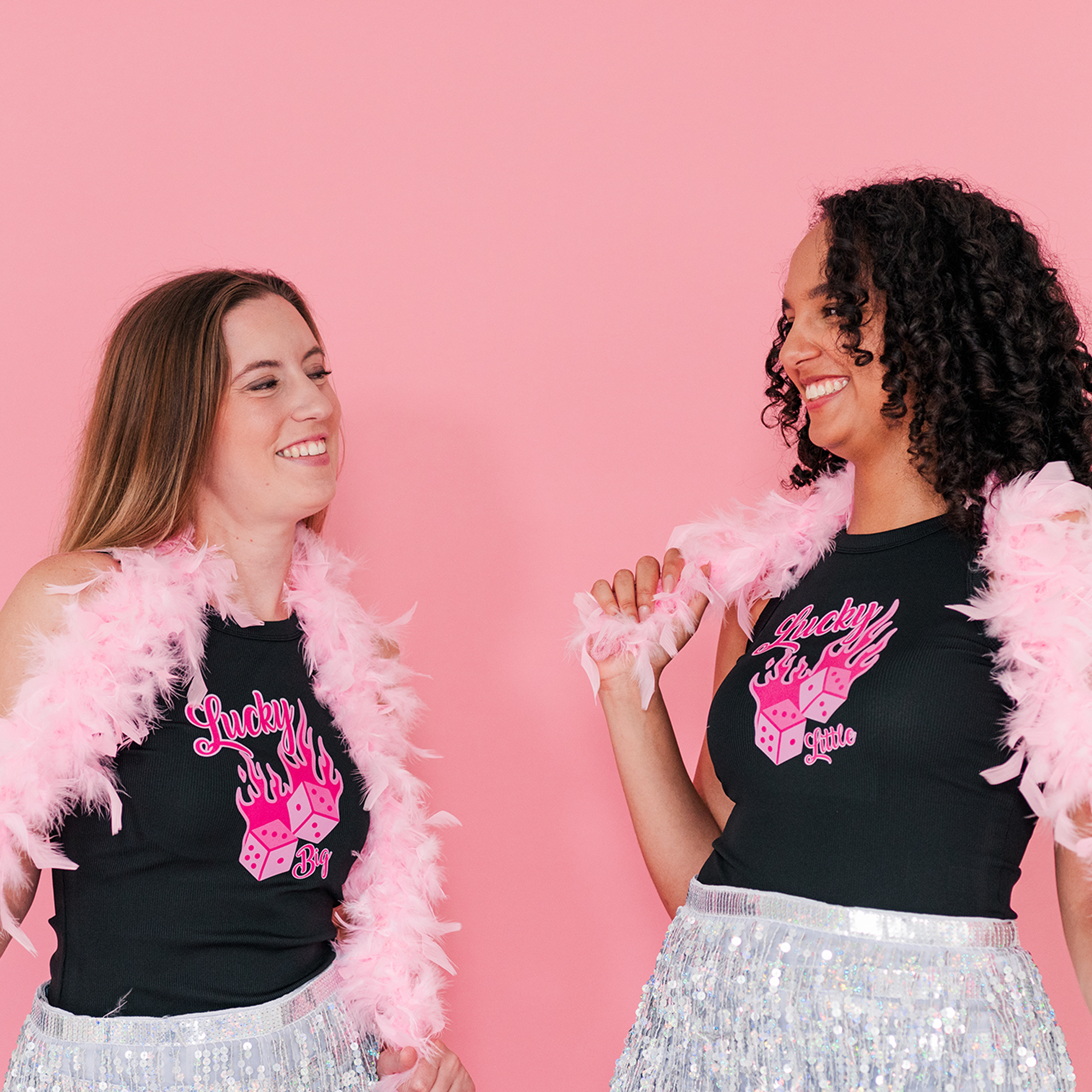 a woman in a black shirt and a woman in a pink feather boa