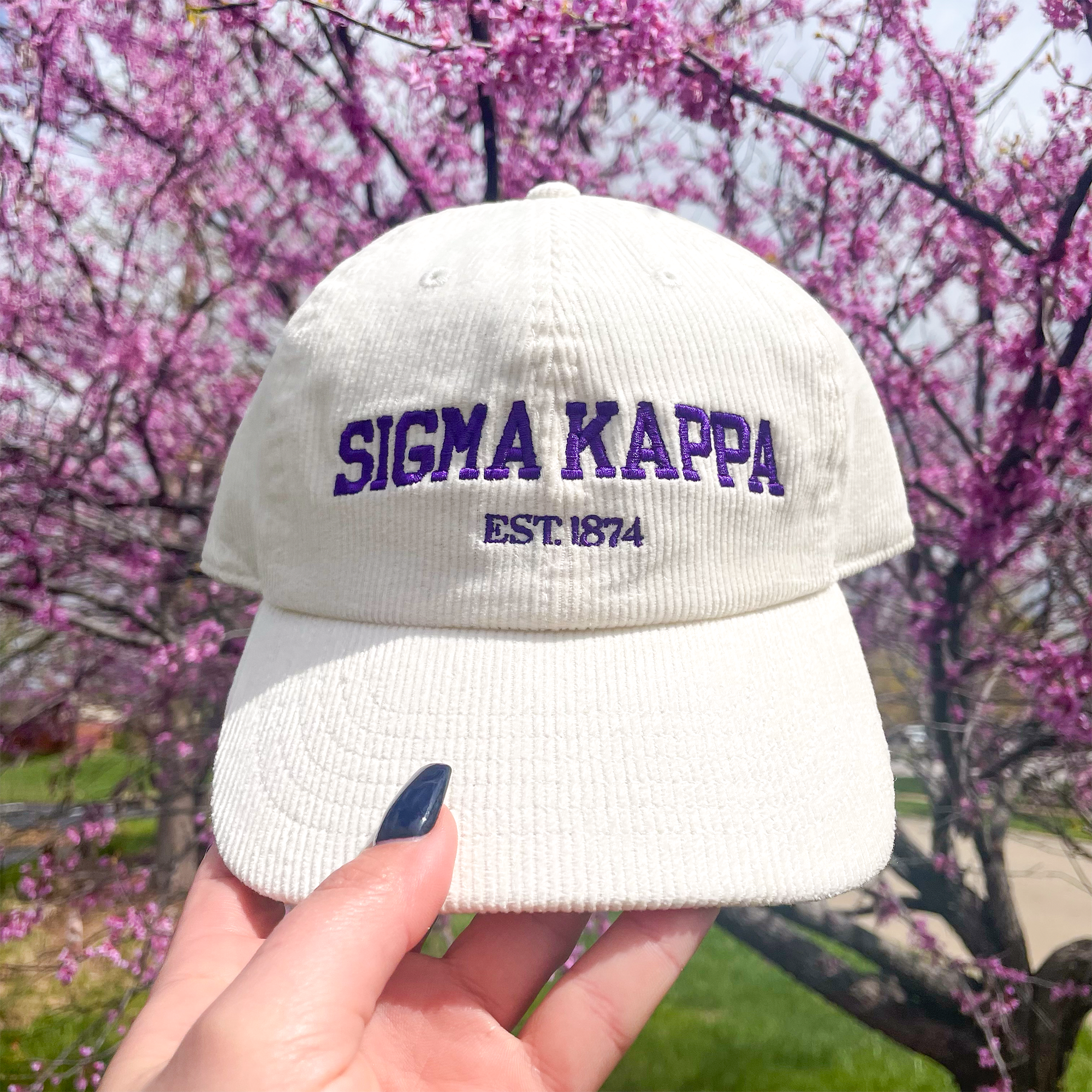 a person holding up a white hat with the word signa kapp on it