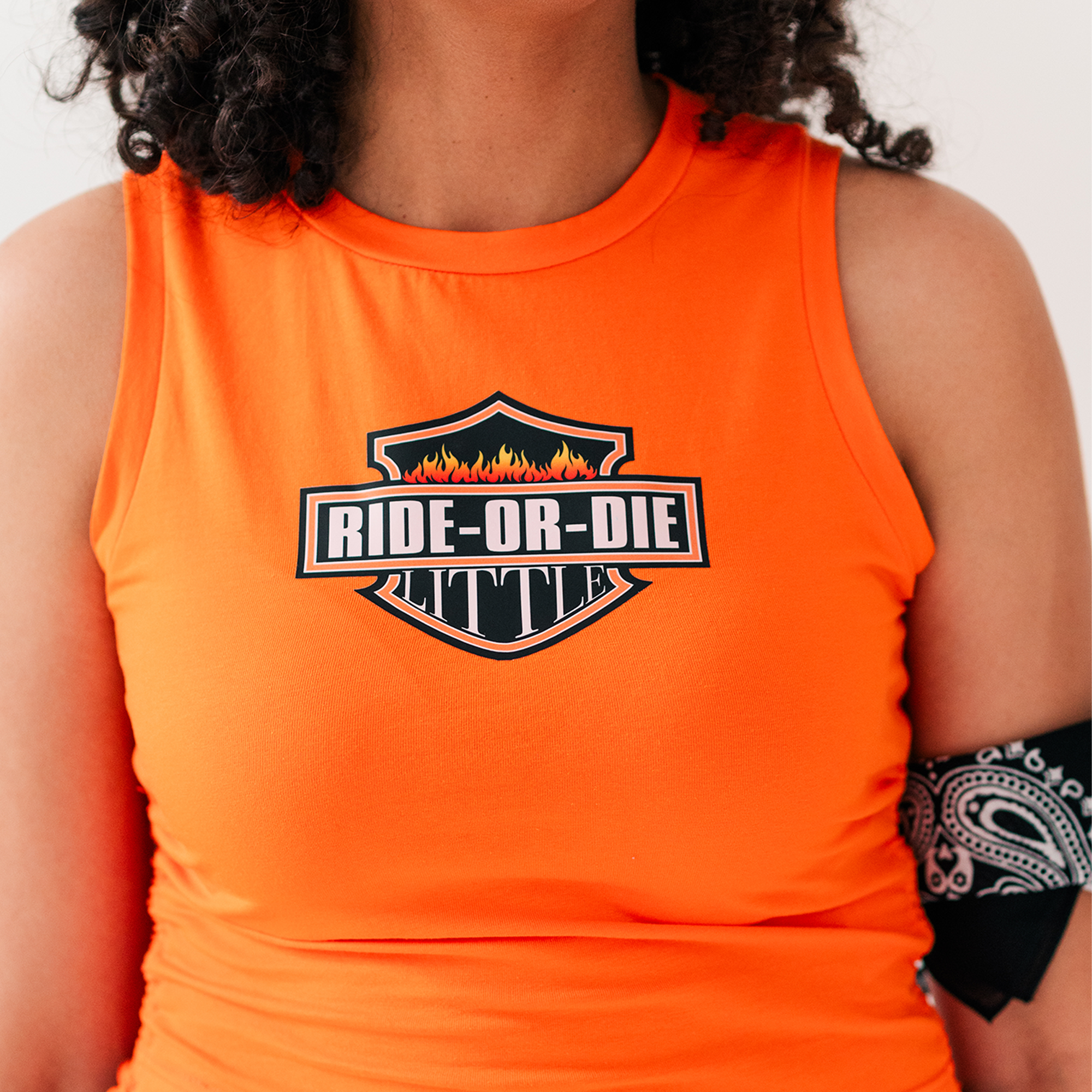 a woman wearing an orange tank top with a logo on it