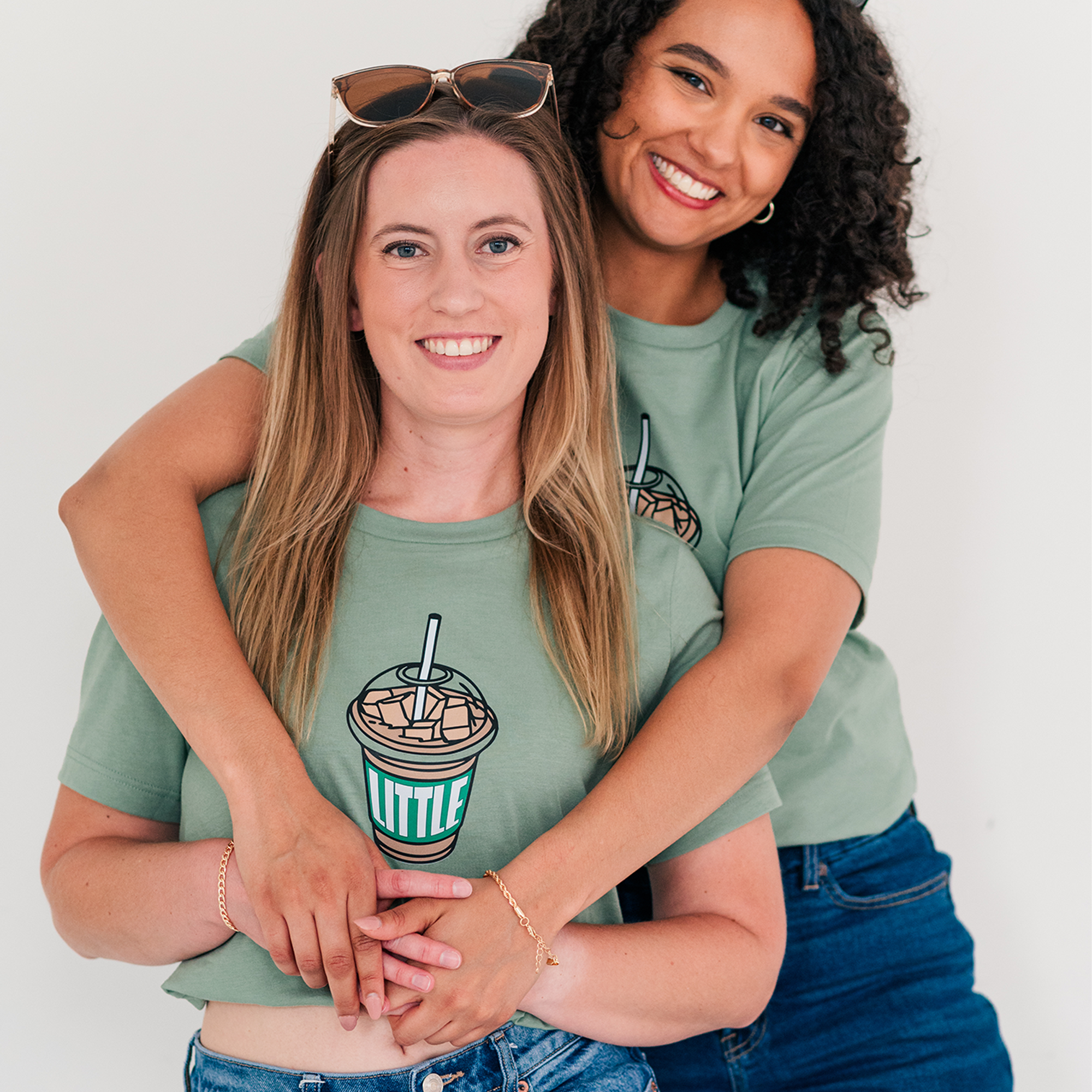 two women hugging each other while wearing matching shirts