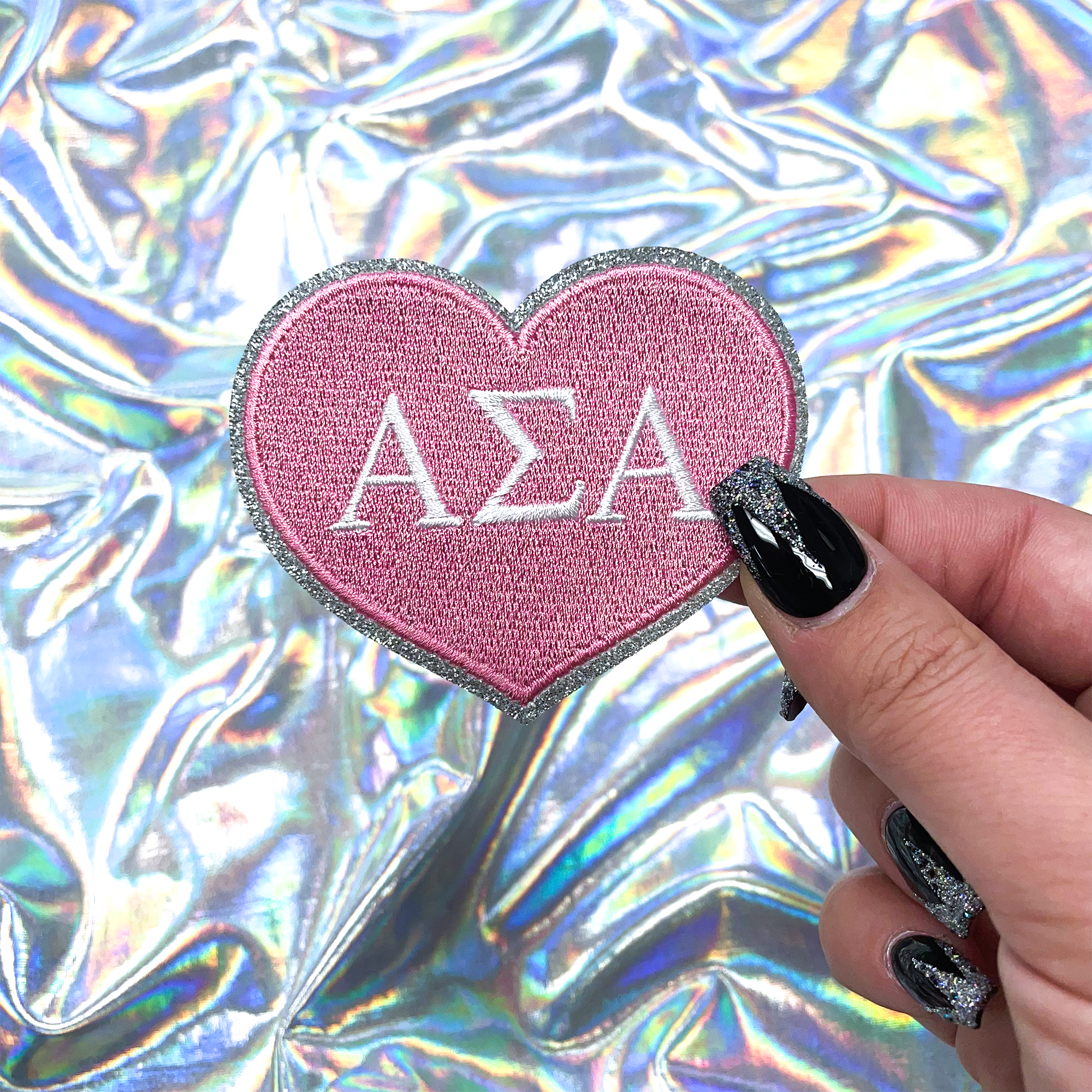 a person holding a pink heart shaped sticker