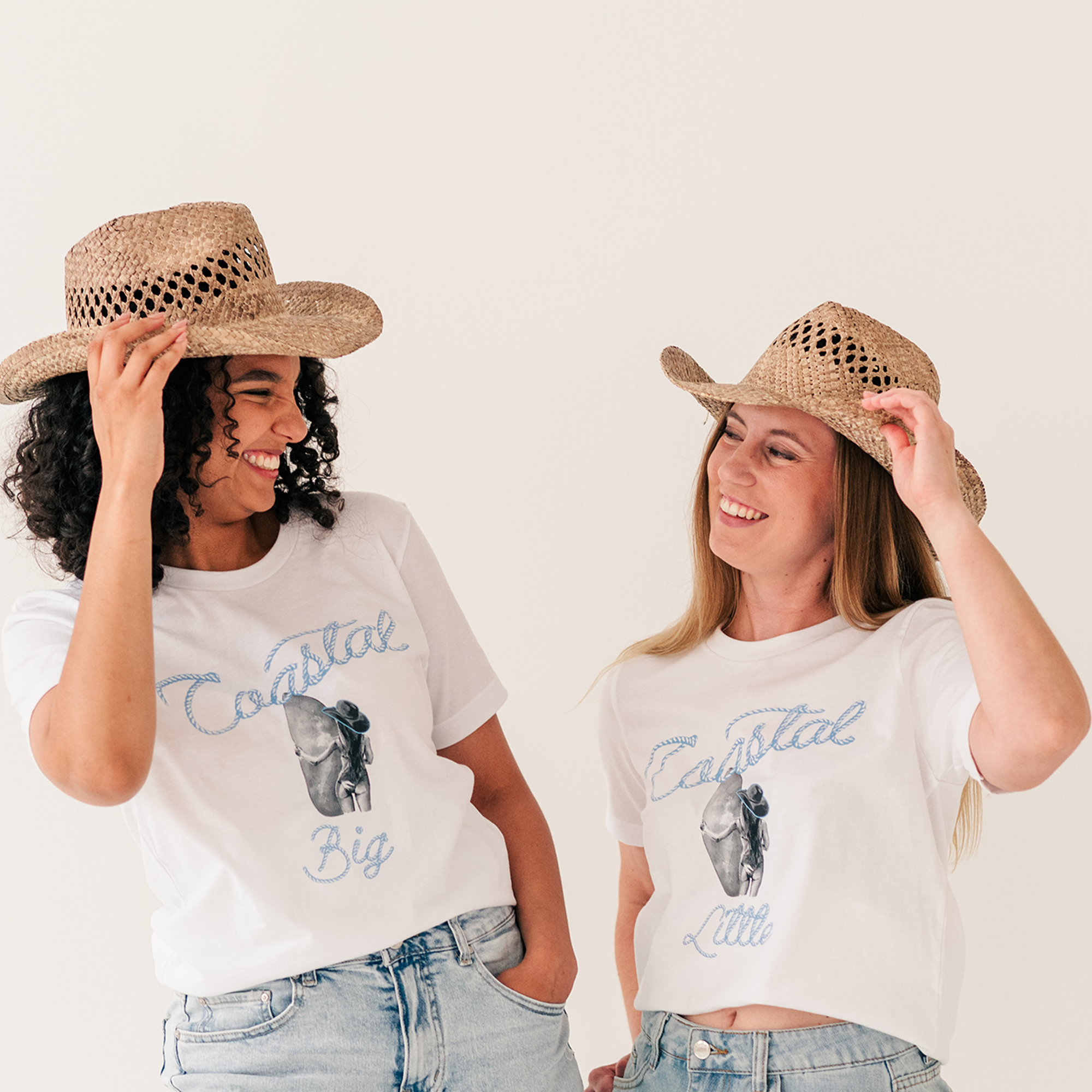 two women wearing matching shirts and hats