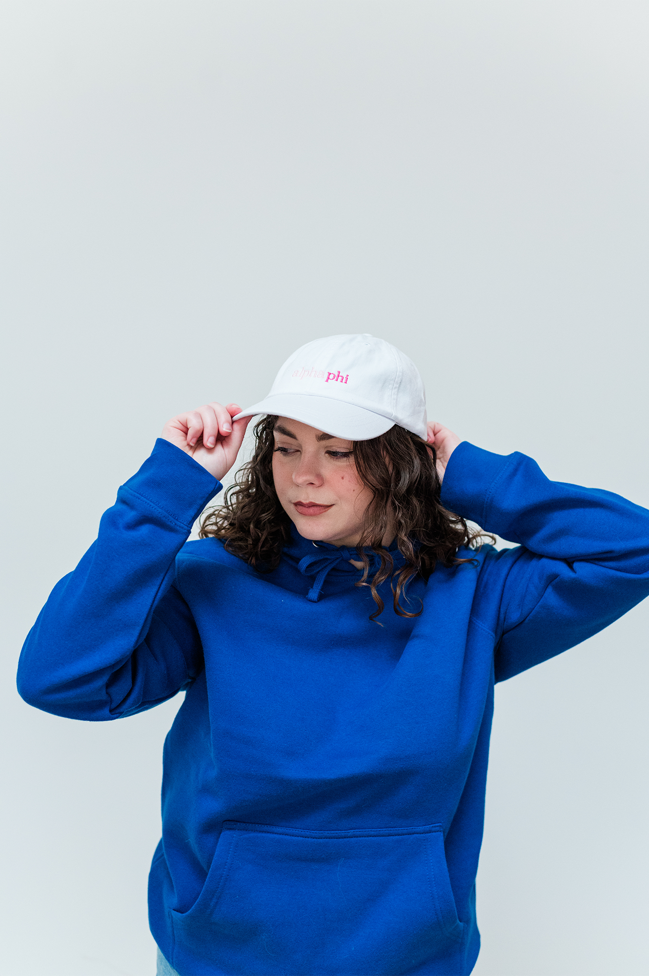 a woman wearing a blue sweatshirt and a white hat