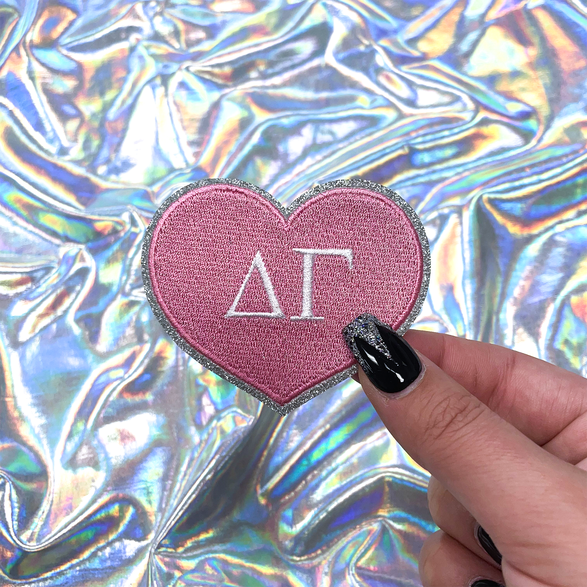 a person holding a heart shaped sticker with the letter a on it