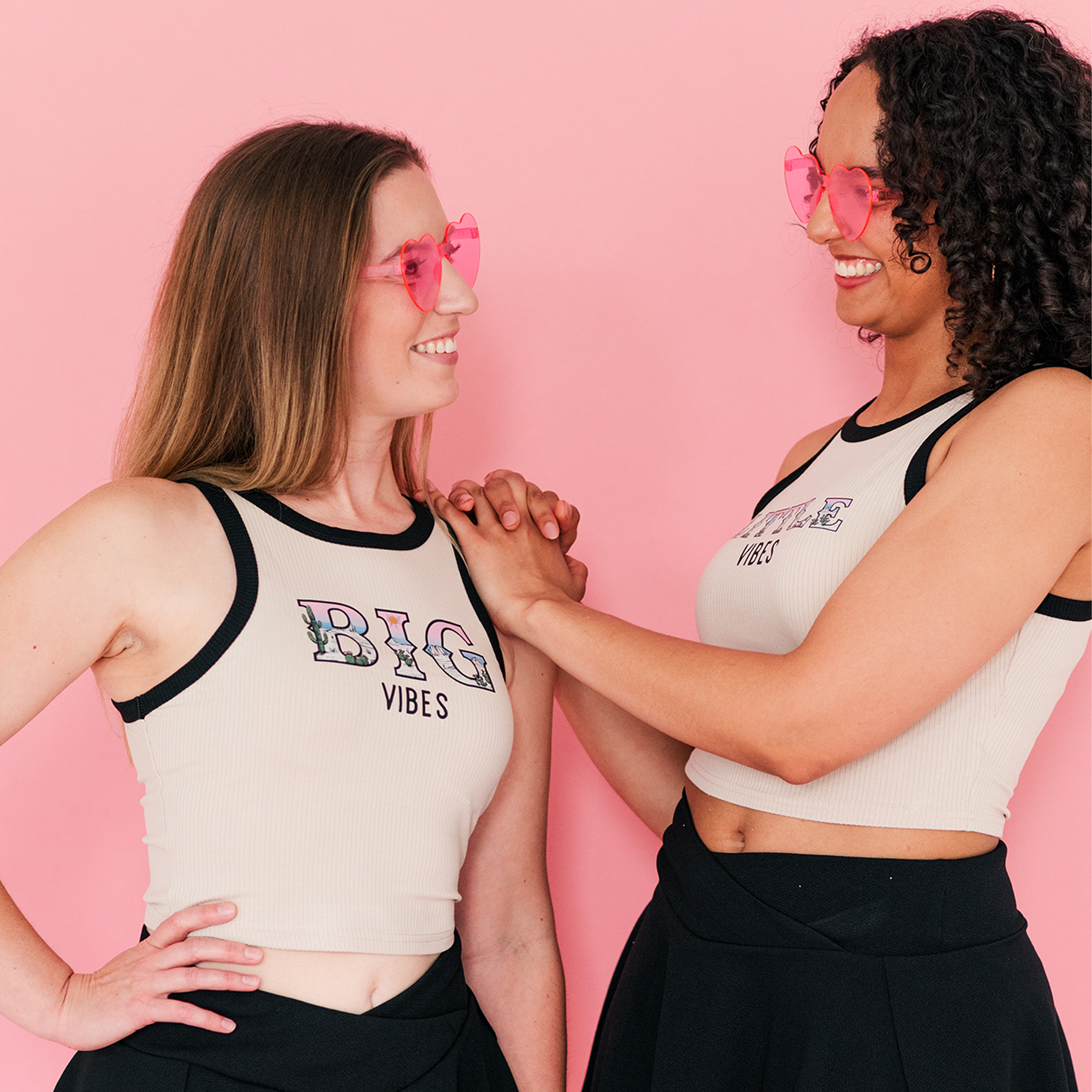 two women wearing pink sunglasses standing next to each other