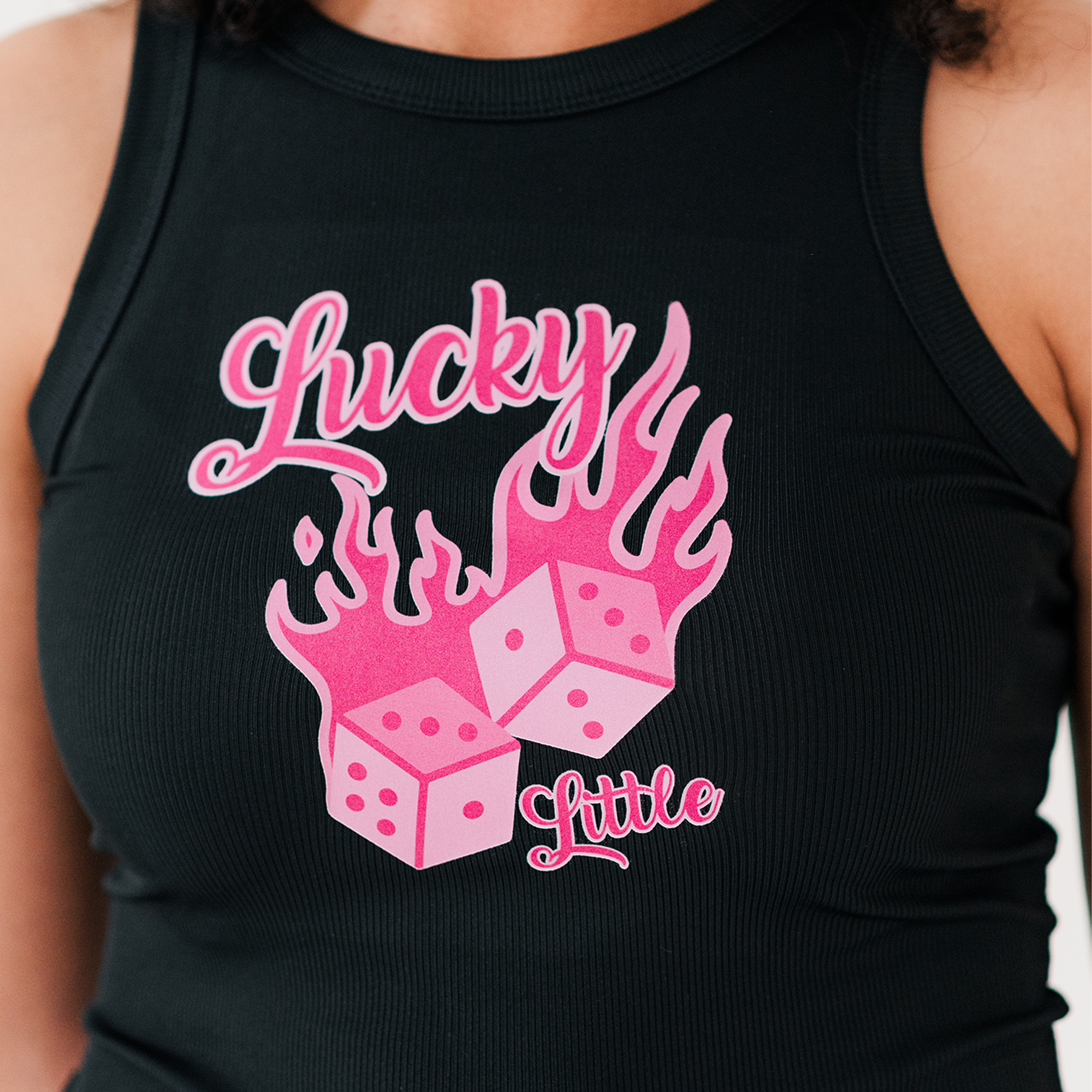 a woman wearing a black tank top with pink dices on it