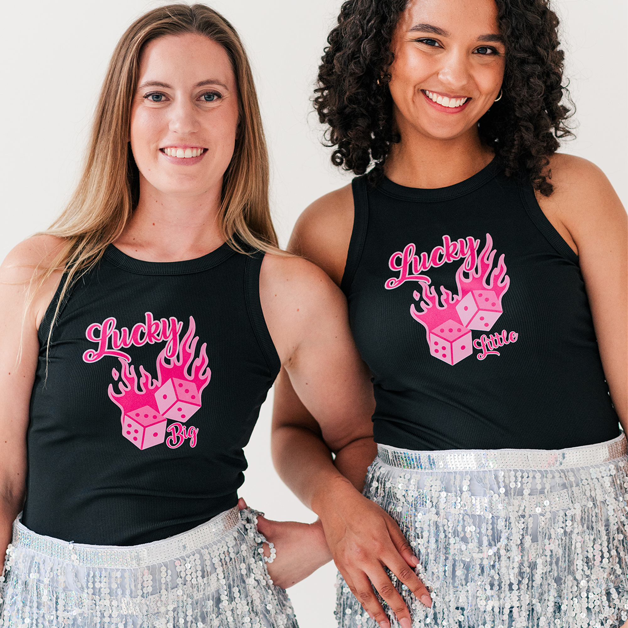 two women wearing matching shirts and sequin skirts