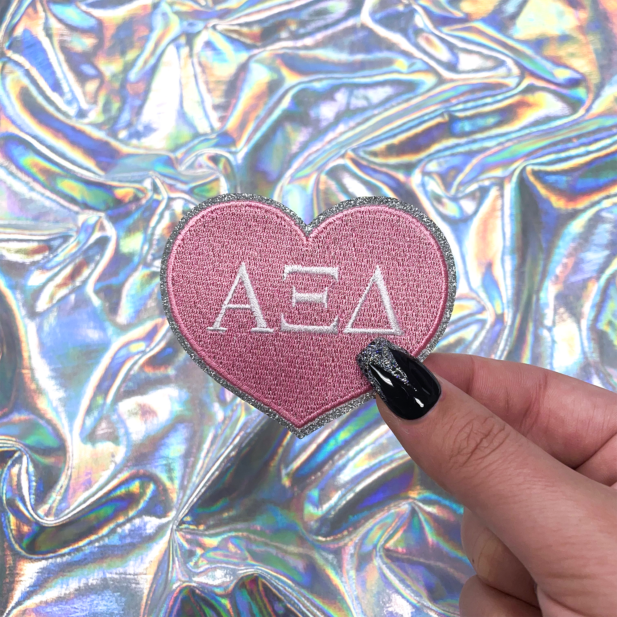 a person holding a heart shaped sticker with the word ae on it