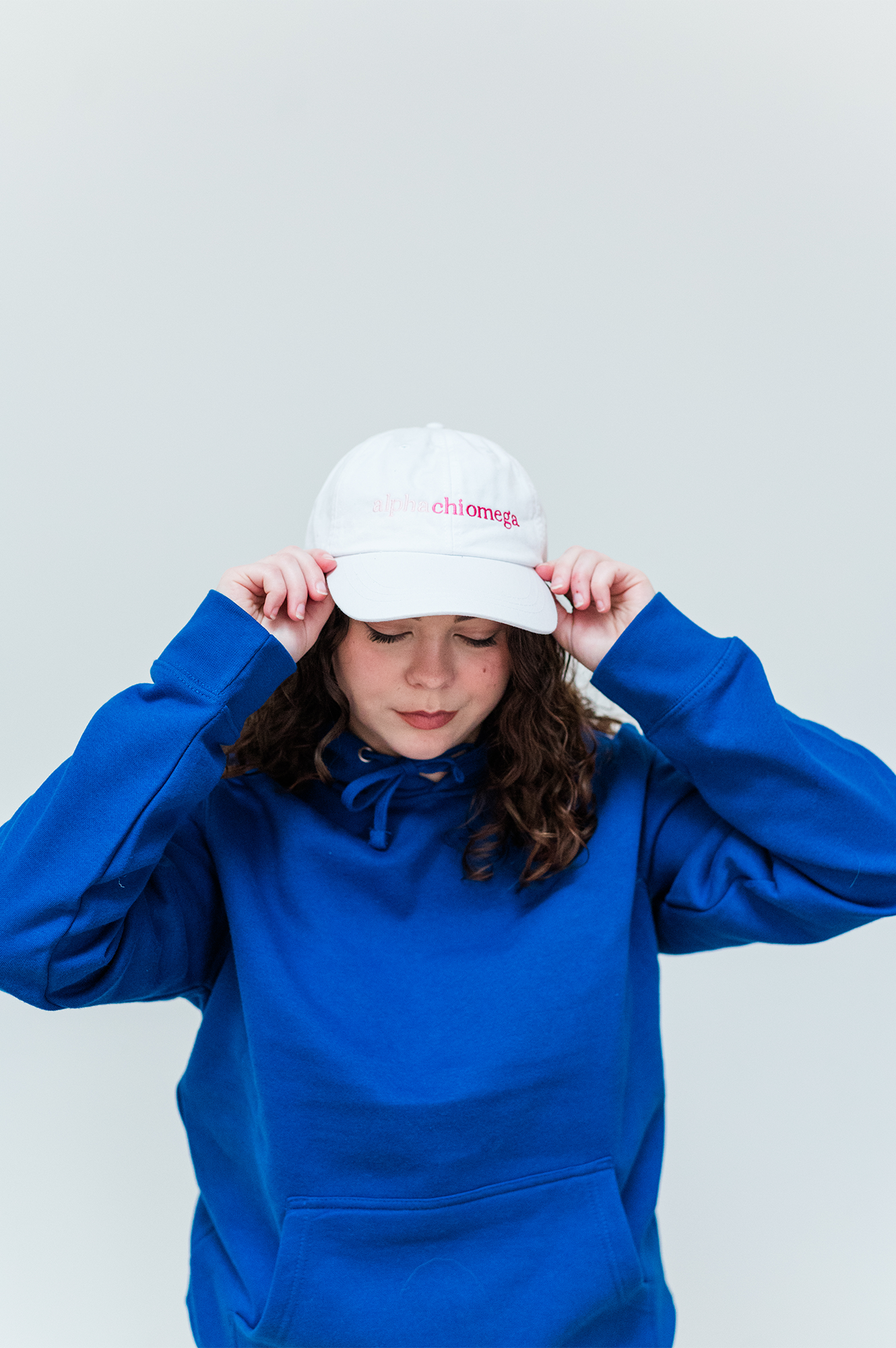 a woman wearing a blue hoodie and a white hat