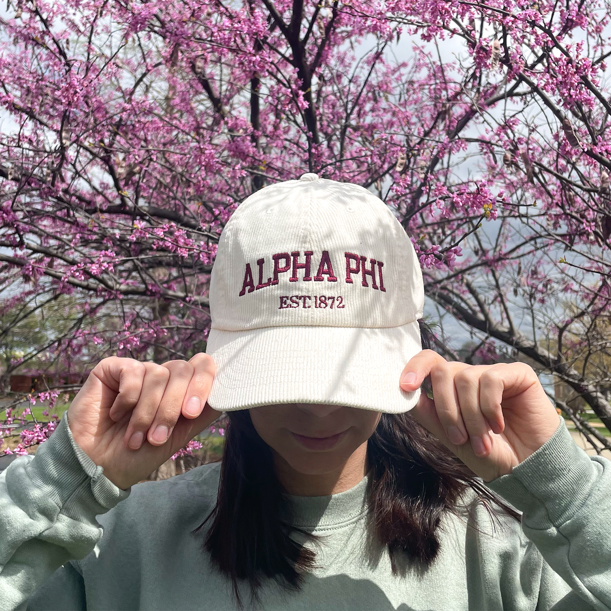 a girl wearing a white hat with the word alpha ph on it